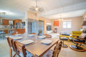 a dining room and living room with a table and chairs at Ma Vie'La - Swimming Pool - Balneo - Jacuzzi - Sauna in Rhinau