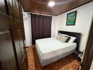 a small bedroom with a bed with white sheets and pillows at Serene Oasis Hideaway in Fortuna
