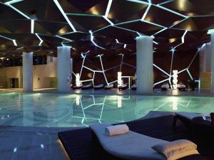 a swimming pool in a building with a ceiling at Sofitel Guangzhou Sunrich in Guangzhou