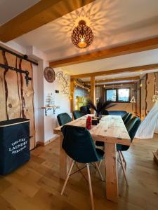 a dining room with a wooden table and green chairs at Chata Malenovice in Malenovice