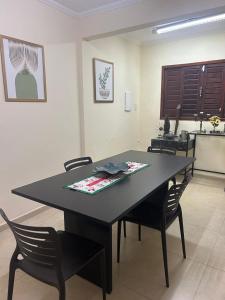 a black table with chairs in a room at Casa grande e aconchegante, muito central, aluguel de quartos in Natal