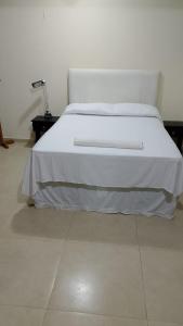 a bedroom with a white bed with a white blanket at Casa grande e aconchegante, muito central, aluguel de quartos in Natal