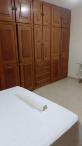 a kitchen with wooden cabinets and a white counter top at Casa grande e aconchegante, muito central, aluguel de quartos in Natal +1 photo