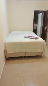 a bed with a blanket on top of it at Casa grande e aconchegante, muito central, aluguel de quartos in Natal