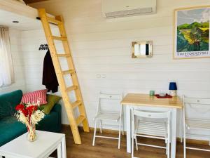 a room with a couch and a table and a ladder at Jemiołucha Glamp in Bodzentyn