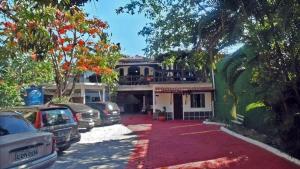 a parking lot with cars parked in front of a house at Pousada Suites Praia de Costazul in Rio das Ostras