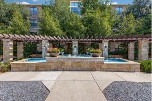 a swimming pool in a garden with a pergola at Cozy & Chic Frisco Scape in Frisco