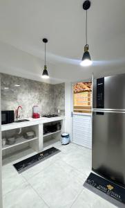 a kitchen with a stainless steel refrigerator in it at Casa Maroka in Japaratinga