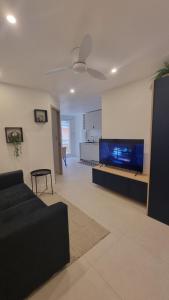 ベルフォールにあるLe Malibuのソファと薄型テレビのあるリビングルーム