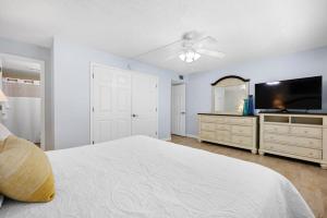 een slaapkamer met een groot bed en een flatscreen-tv bij Cocoa Beach Club-Beachfront Condo in Cape Canaveral