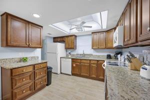 een keuken met houten kasten en een plafondventilator bij Cocoa Beach Club-Beachfront Condo in Cape Canaveral