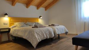 una camera da letto con un letto con due asciugamani sopra di La Cantizada a Viloria