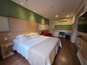 a bedroom with a white bed and a green wall at Mercure Nações Unidas - Apto 910 in Sao Paulo +10 photos