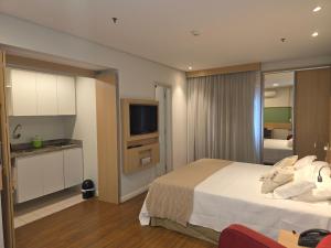 a hotel room with a bed and a television at Mercure Nações Unidas - Apto 910 in Sao Paulo
