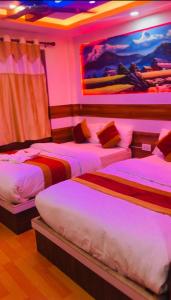duas camas num quarto com iluminação rosa em Pokhara hotel Pvt Ltd Ktm em Catmandu