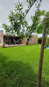 una casa con un patio verde con un árbol en Pura paz y relax en entorno super tranquilo, en Mar del Plata 42 fotos más
