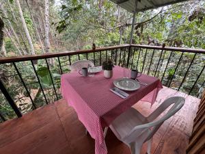 een tafel met een roze tafelkleed op een dek bij Mountain Retreat Refugio de Aves in Turrialba