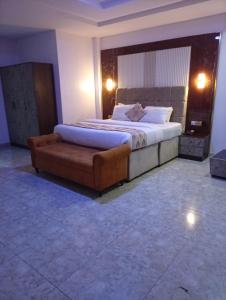 a bedroom with a large bed and a couch at De Baylux Hotel and Suites, Lekki, Lagos in Maiyegun