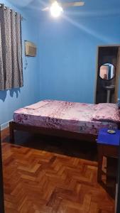 Hotel Flamingo's في سانتوس: سرير في غرفة ذات جدار ازرق