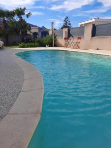 a swimming pool with blue water in a yard at Voie bleue Bords du Rhône in Guilherand