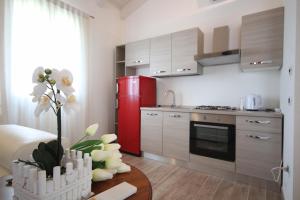 a kitchen with a red refrigerator and a table with flowers at Relax garden villa 1ora da venezia VILLABRUNA in Correzzola
