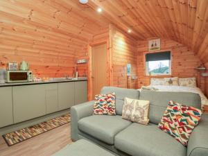 a living room with a couch and a kitchen in a log cabin at Rowan in Ulverston