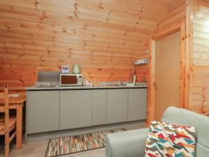 a kitchen in a log cabin with a microwave at Rowan in Ulverston