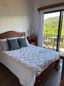 La Casa Bonita في مونتيفيردي كوستاريكا: غرفة نوم مع سرير وبلكونة مع طاولة