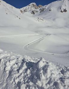 a group of people skiing down a snow covered mountain at PIAZZETTA DEL FORNO GRAZIOSO BILOCALE ad ASSERGI in Assergi
