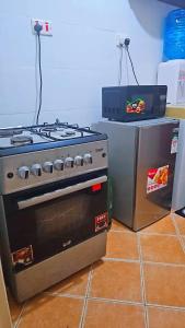 a stove and a microwave in a kitchen at Kilifi Beach Haven -Cozy 1 bedroom apartment in Kilifi