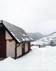 a building with snow on the roof of it at Zoranovi konaci in Jevtići