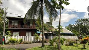 a house with a palm tree in front of it at Cabañas Arrecifes in El Valle