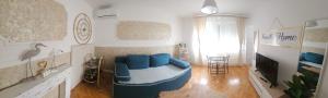 a living room with a blue couch and a tv at FRIENDLY HOME in Tuzla