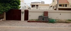 a house with two brown doors on a street at Royal Continental DHA Karachi in Karachi