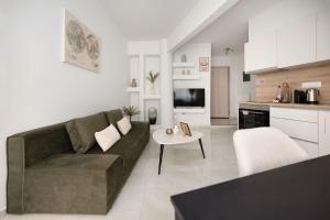 Executive Suite - Estia Premium Apartments في سلانيك: غرفة معيشة بها أريكة وطاولة