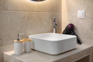 Executive Suite - Estia Premium Apartments في سلانيك: وجود مغسلة بيضاء جالسة على كونتر في الحمام +13 صورة