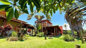 Rancho Recanto da Serra في ديلفينوبوليس: منزل أمامه ساحة فيها نخل