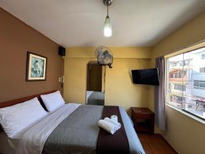 a bedroom with a bed with a teddy bear on it at La Posada del Rey - Lima Airport Hostel in Lima +14 photos