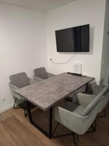 a dining room table with chairs and a television on a wall at Wohnung in toller City-Lage 45 m2 in Vienna