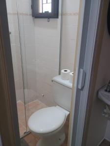 a bathroom with a toilet and a glass shower at Kitnet no interior de São Paulo 25 in Serra Negra