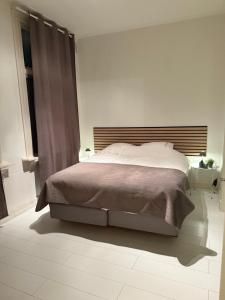 a white bedroom with a large bed and a window at 't Zusje in Enschede