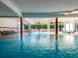 a swimming pool with blue water in a building at Elegant eingerichtete Ferienwohnung in Granzow