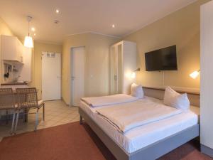 a bedroom with a bed and a tv on the wall at Ferienwohnung im Aparthotel Seepanorama in Granzow +26 photos