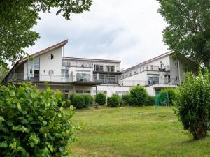 a large white building with a green yard at Ferienwohnung im Aparthotel Seepanorama in Granzow