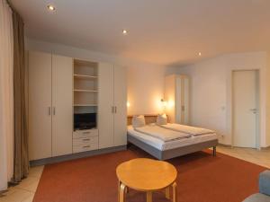 a bedroom with a bed and a table and a chair at Ferienwohnung im Aparthotel Seepanorama in Granzow +28 photos