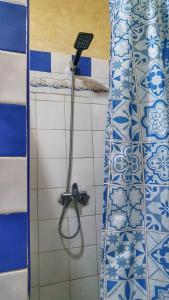 y baño con ducha y azulejos azules y blancos. en Ocean Hideaway - Sea View, en Essaouira