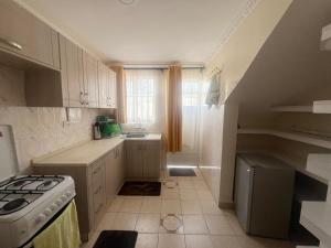 a kitchen with white cabinets and a stove top oven at Cleo Luxe Villa , Spacious 4-Bedroom Maisonette in Sabaki Near SGR & JKIA in Makandara