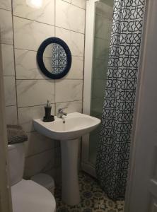 a bathroom with a sink and a mirror and a toilet at Le Petit Logis Noblat 1 in Saint-Léonard-de-Noblat