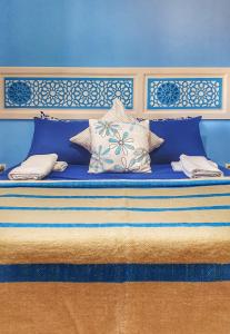 a large bed with blue walls and pillows on it at Ocean Hideaway - Sea View in Essaouira