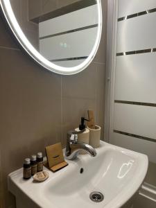 a bathroom sink with a round mirror above it at Ultracentral 13 in Craiova